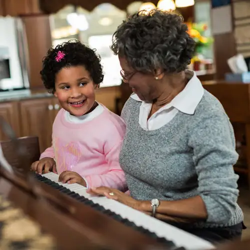 Senior playing piano with grandchild